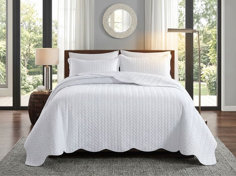 White embossed quilt corner stretched across a queen mattress