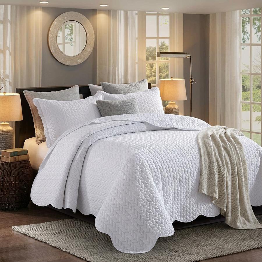 White embossed quilt set on a queen bed