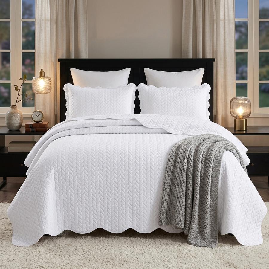 White embossed quilt set on a king bed